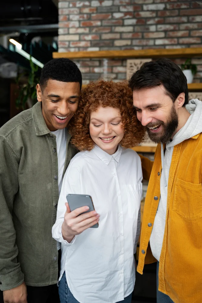 Trois amis regarde un smartphone