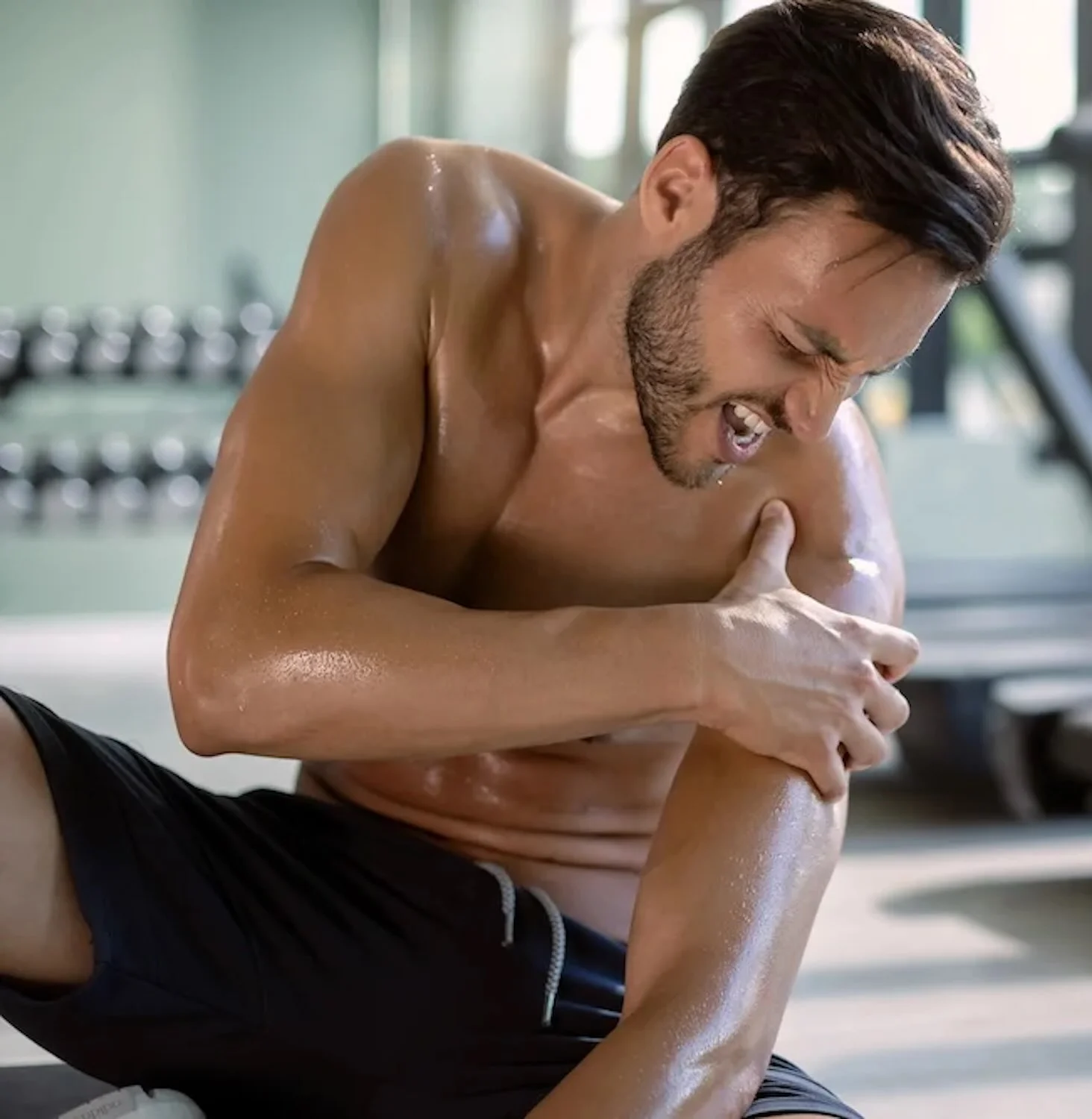 Un sportif qui se tient l'épaule suite à une douleur